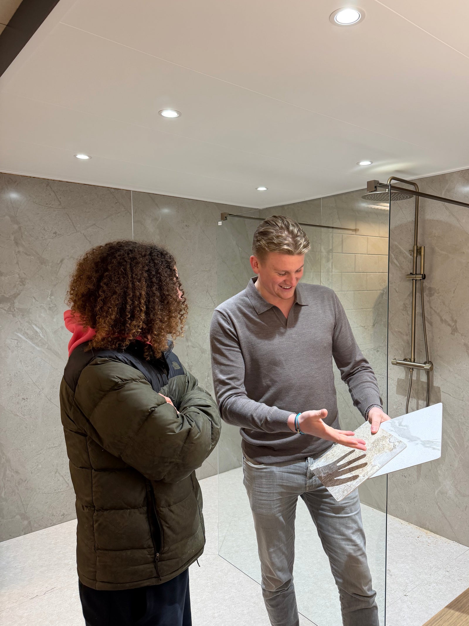 Adviseur legt een klant de mogelijkheden en kosten uit in de showroom