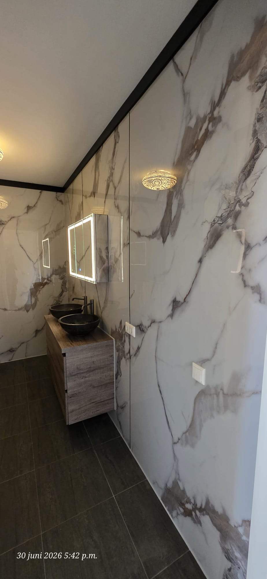 Marmerlook badkamer met donker zwevend meubel
